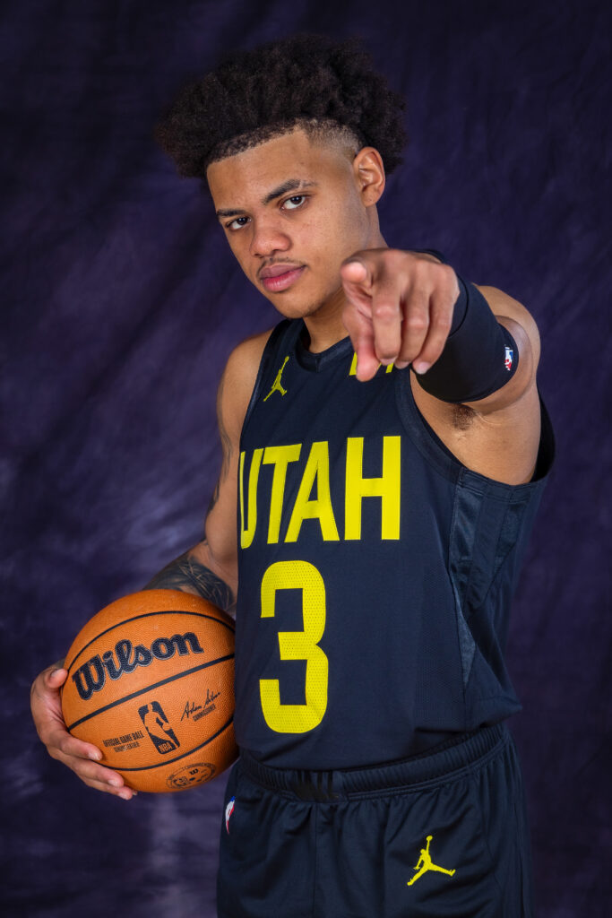 Keyonte George portrait during Utah Jazz NBA Media Day holding a basketball under colored studio lighting.