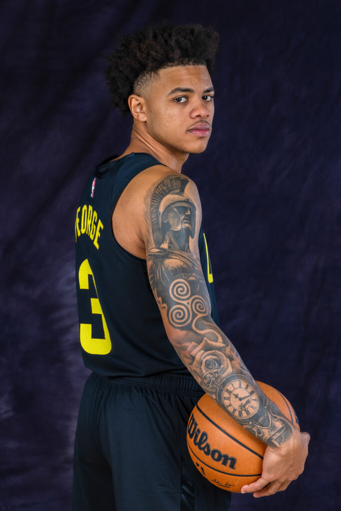 Keyonte George portrait during Utah Jazz NBA Media Day holding a basketball under colored studio lighting.