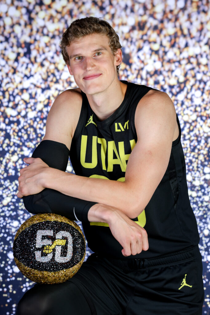 Lauri Markkanen portrait during Utah Jazz NBA Media Day holding a basketball under colored studio lighting.