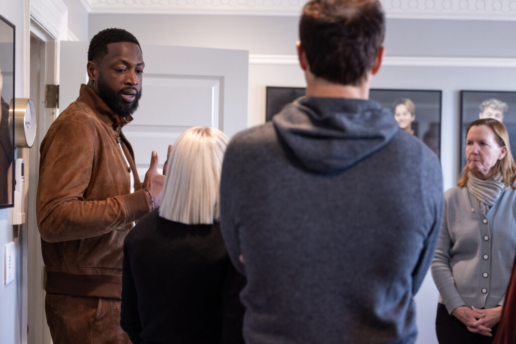 Dwyane Wade asks questions on a tour of the Encircle House in Salt Lake City during and NBA Cares Community Event 