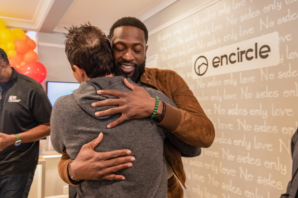 Dwyane Wade and Gabrielle Union speak with Ryan Smith during a visit to Encircle House.