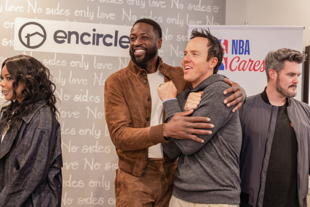 Dwyane Wade and Gabrielle Union speak with Ryan Smith during a visit to Encircle House.