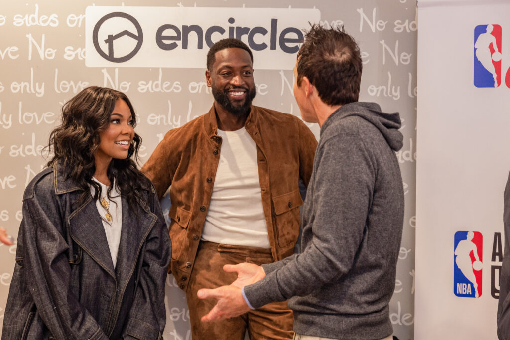 Dwyane Wade and Gabrielle Union speak with Ryan Smith during a visit to Encircle House.