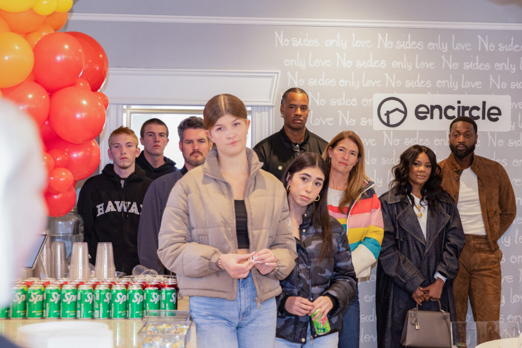 Dwyane Wade and Gabrielle Union speak with Ryan Smith during a visit to Encircle House.