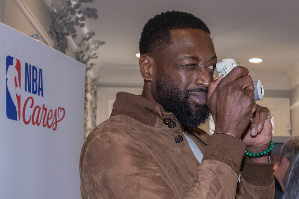 Dwyane Wade visit the Encircle House and takes a photograph with a polaroid camera 