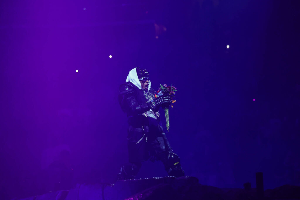 Travis Scott performing live in concert during a high-energy hip hop stage performance