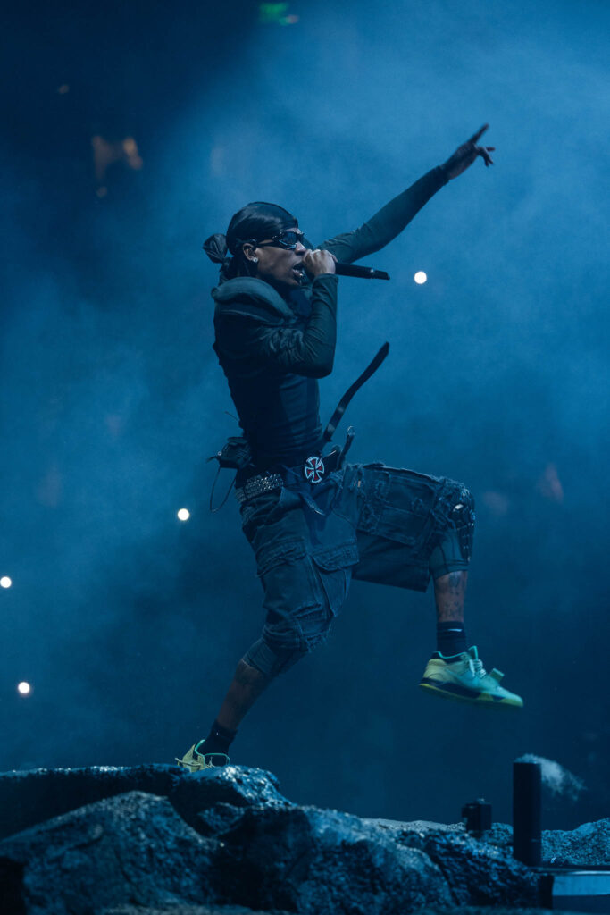 Travis Scott performing live in concert during a high-energy hip hop stage performance