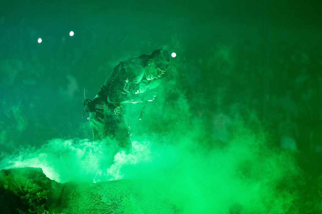 Travis Scott performing live in concert during a high-energy hip hop stage performance