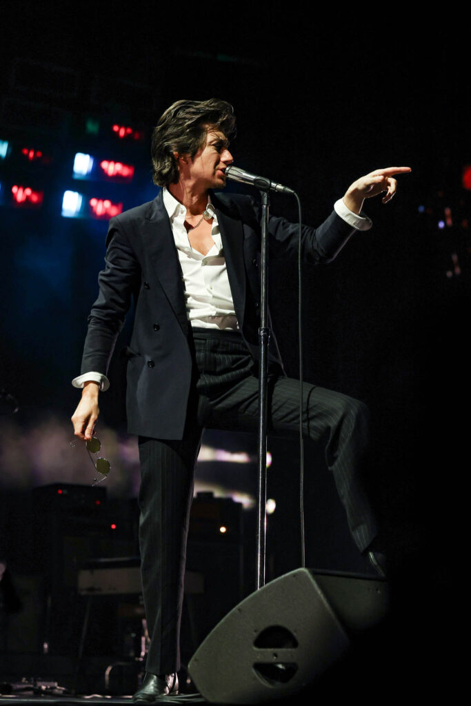 Arctic Monkeys live concert performance with stage lighting and crowd atmosphere