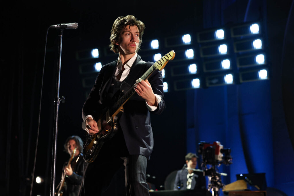 Arctic Monkeys live concert performance with stage lighting and crowd atmosphere