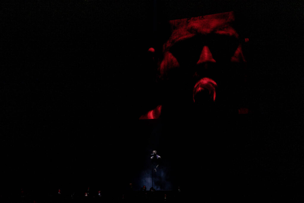 Post Malone live concert performance with stage lighting and crowd atmosphere