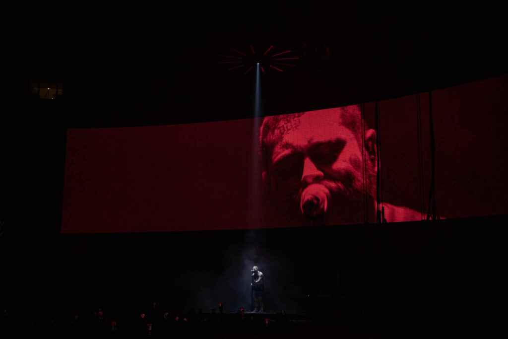 Post Malone live concert performance with stage lighting and crowd atmosphere