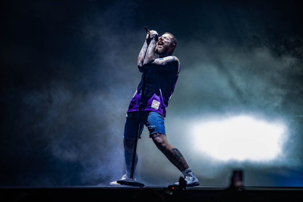 Post Malone live concert performance with stage lighting and crowd atmosphere