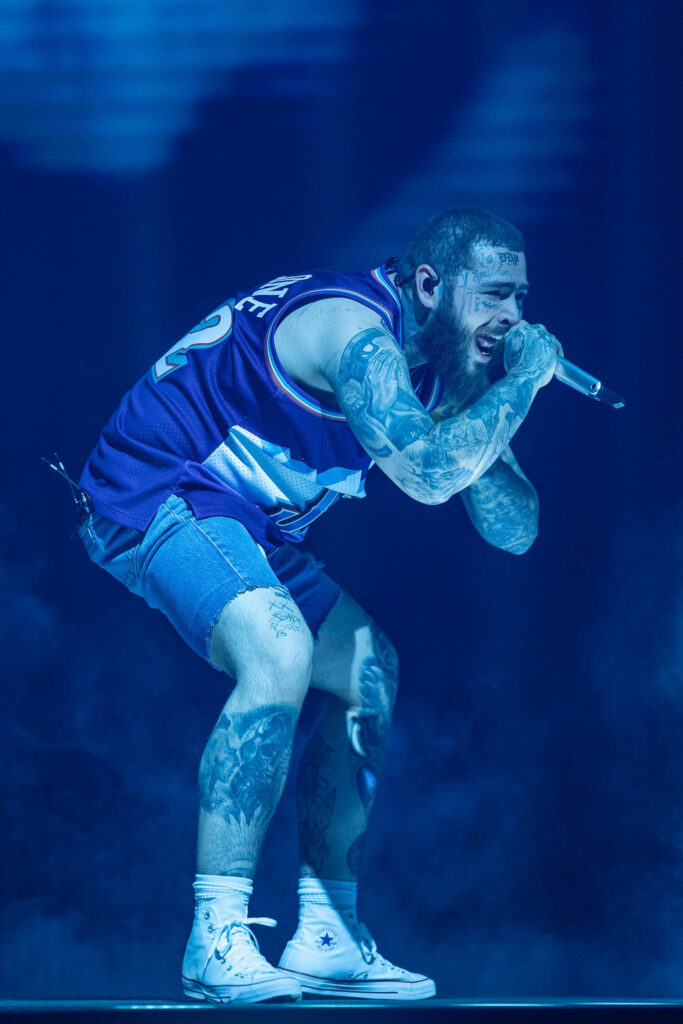 Post Malone performing live in concert during a high-energy stage performance
