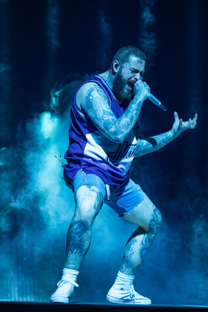 Post Malone performing live in concert during a high-energy stage performance