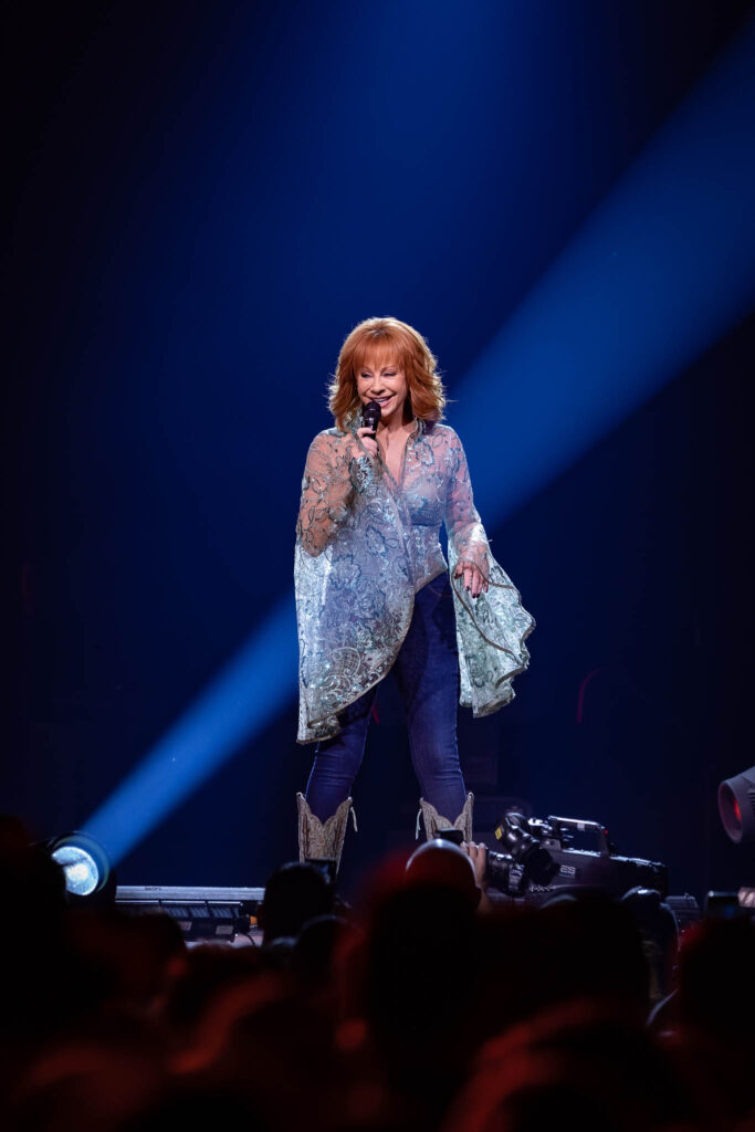 Reba McEntire live concert performance with stage lighting and audience atmosphere