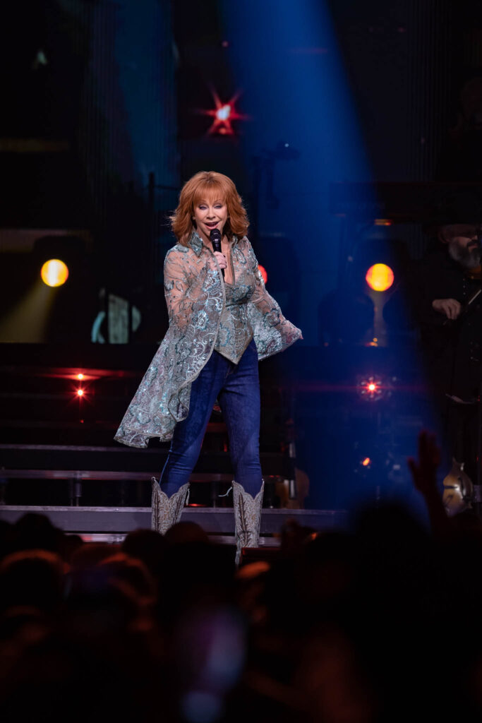 Reba McEntire live concert performance with stage lighting and audience atmosphere
