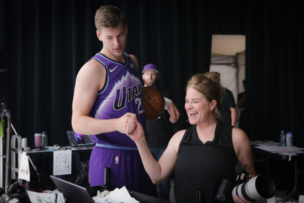 Utah Jazz player Kyle Filipowski reviewing images with photographer Melissa Majchrzak during an NBA media day branding photo shoot.